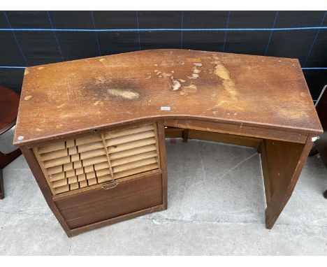 AN UNUSUAL MID CENTURY CURVED DESK WITH DROP DOWN ROLLER SHUTTER COMPARTMENT AND SHALLOW DRAWER - 50" WIDE 