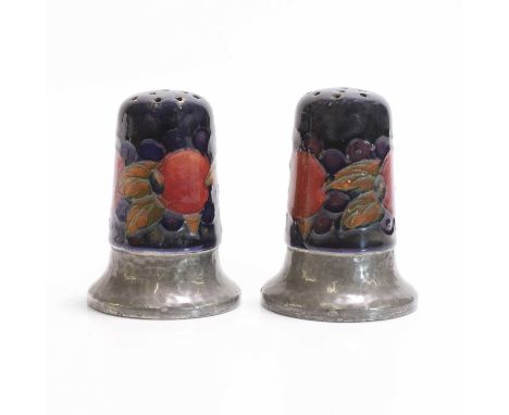 William Moorcroft (1872-1945), two Tudric 'Pomegranate' pepper pots, for Moorcroft Pottery and Liberty &amp; Co., London, gla