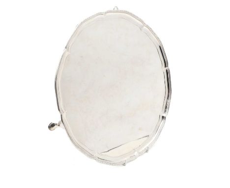 A silver salver London 1927, by Asprey, the circular centre within a piecrust and beadwork border, on paw feet31cm diameter30