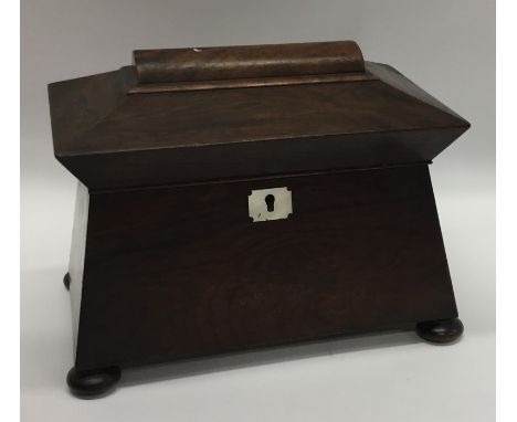 A rosewood sarcophagus shaped tea caddy with fitted interior. Est. £25 - £35.