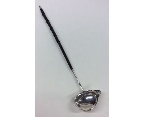 A Georgian silver toddy ladle with pouring lip and silver mounted whalebone handle. Est. £20 - £30.