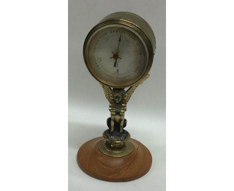 A small brass aneroid barometer on stand. Est. £30 - £50.