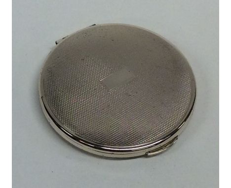 A modern silver engine turned compact with hinged top. Approx. 70 grams. est. £20 - £30.