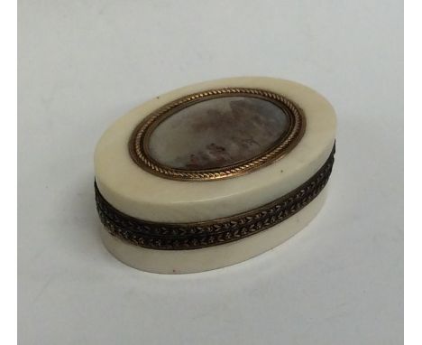 An attractive oval Antique ivory silver and gold mounted lady's compact attractively decorated with a street scene, with fitt