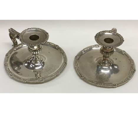 A rare pair of William IV silver chamber sticks with crested armorials, gadroon rims to leaves thumb pieces. London 1851/49. 