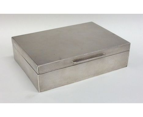A rectangular engine turned silver cigarette box with fitted interior. London. By Goldsmiths &amp; Silversmiths. Approx. 580 