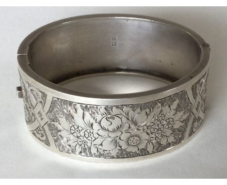 An Edwardian attractively engraved bangle with concealed clasp. Approx. 26 grams. Est. £40 - £50