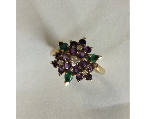 An 18 carat gold emerald, ruby and amethyst cluster ring. Approx. 5.5 grams. Est. £100 - £150