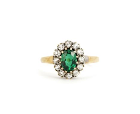 A hallmarked 9ct yellow gold ring set with an oval cut green stone surrounded by white stones, (N).