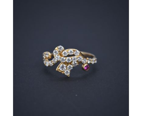 An 18ct rose gold (marked 790) ring set with a round cut ruby and white stones, (Q).