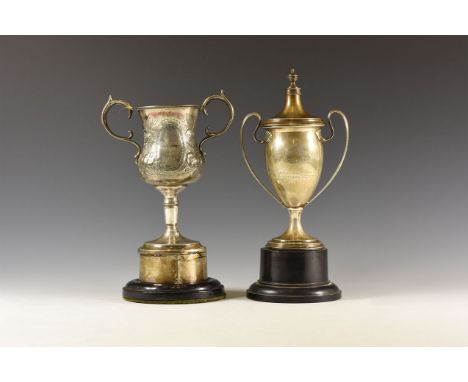 20th century AD. Group comprising: a hallmarked silver two-handled prize cup with lid, affixed to black base, cup inscribed '