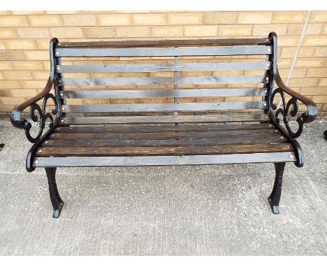A cast iron garden bench with wooden slats 78cm x 128cm x 66cm