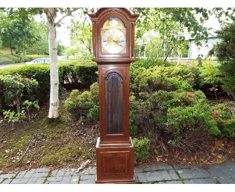 A 20th century weight driven longcase clock, the case with glazed door to display the pendulum and weights, brass arched dial