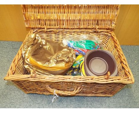 A wicker picnic hamper with contents