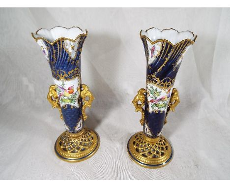 A pair of Royal Worcester reticulated bud vases decorated with depictions of birds on a cobalt blue ground with gilded accent