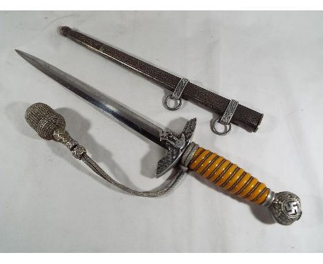 A Third Reich German Luftwaffe dagger with woven white metal wire bound orange celluloid grip, the white metal hilt depicting