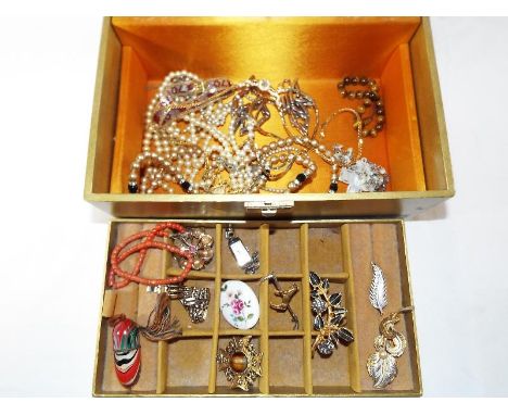 A musical jewellery box of costume jewellery to include a silver brooch in the form of a leaf, a mother of pearl and white me