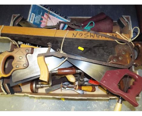 A collection of vintage hand tools to include saws, brace, clamps and similar