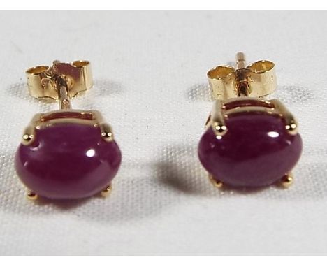 A lady's pair of 9ct gold earrings, set with ruby cabochon