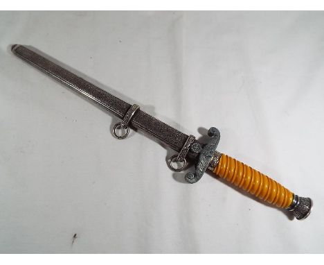 A Third Reich German dagger with white double ring scabbard with white metal hilt depicting eagle and swastika, marked to the