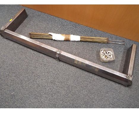 A collection of brass stair rods with fittings and a white metal Art Deco style fender