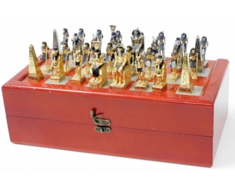 A red stained beech games box, with a chessboard top, together with an Ancient Egyptian style metal chess set.