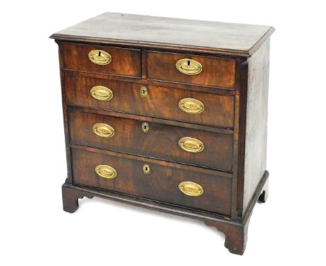 A George III mahogany chest of drawers, with a moulded edge, above two short and three long drawers, each with oval pressed b