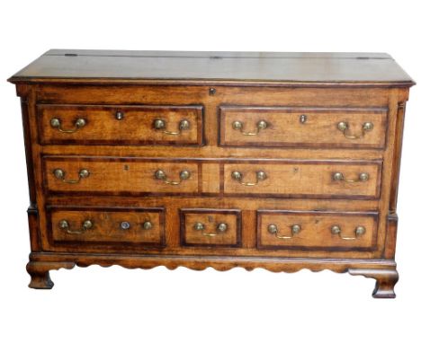 A 19thC Lancashire oak and mahogany cross banded chest, the hinged top above two dummy drawers, with one long drawer and thre