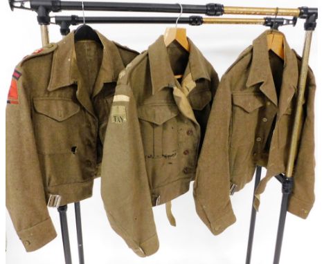 Three World War II British Army battle dress serge shirts, one bearing applied badges for the Royal Artillery, another for Ho