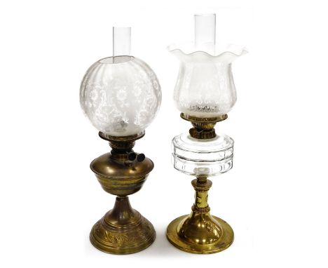 An Arts and Crafts brass and cut glass oil lamp, with a glass chimney and etched glass shade, 57cm high, together with a dupl