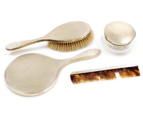 A 20thC four piece silver mounted matched dressing table set, with engine turned decoration, comprising comb, hairbrush, hand