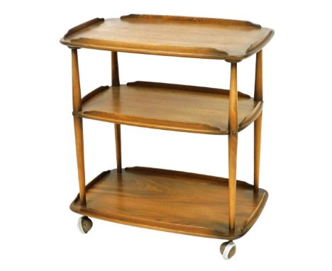 An Ercol light elm three tier trolley, raised on castors, 78cm high, 69cm wide, 45cm deep. 