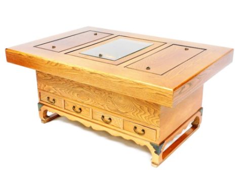 A Chinese elm hibachi coffee table, the top with three copper lined recesses, two with wooden covers the other with a glass c