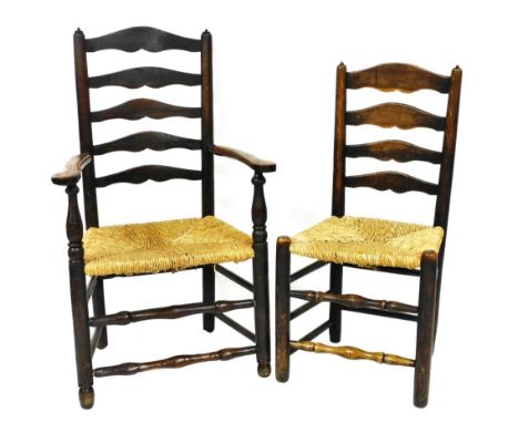 A 19thC country made ash ladder back armchair, with rush seat on turned tapering legs, and a matching side chair. 