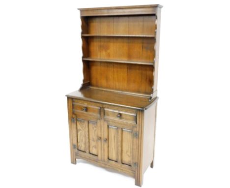An Ercol style oak dresser, the raised back with two shelves, the base with rounded edges, two frieze drawers and two further