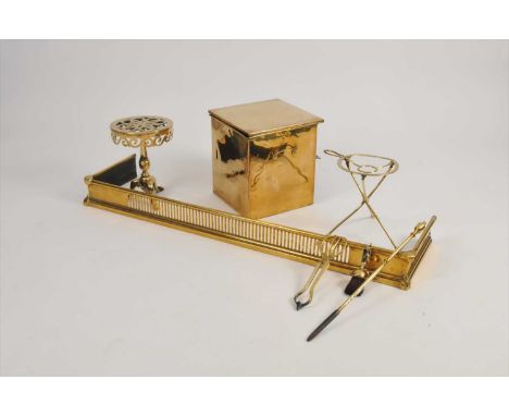 A collection of brassware to include a lidded coal box, two fire fenders, a very heavy trivet in the form of a miniature trip