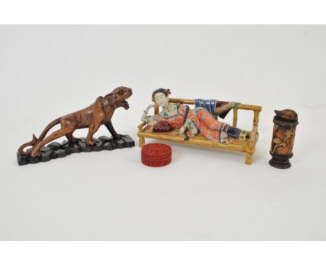 An early 20th century Japanese carved hardwood study of a tiger with painted striped detail and inset glass eyes, 12 cm high,