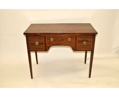 An Edwardian mahogany desk, with cross-banded inlaid borders, the over-hanging top above a central long narrow and two flakin