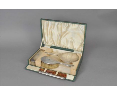 A cased four piece silver mounted dressing table set, Birmingham 1908, comprising; a hand mirror, hair brush and comb