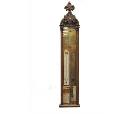 An oak cased 19th century Admiral Fitzroy type barometer, glazed beneath a Gothic carved fleur de lis finial, 122 x 25cm.