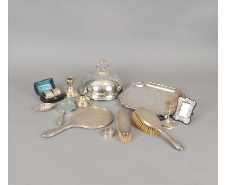 A silver backed mirror, brush and clothes brush, together with a plated salver and lid, silver napkin rings, a small silver m