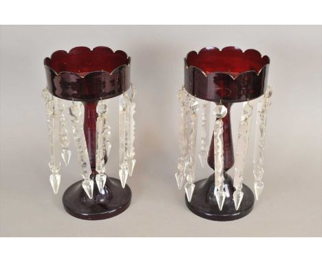 A pair of Victorian ruby glass table lustres, with hanging clear cut prism droplets, each 33 cm high.