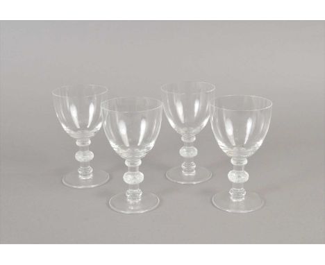 A set of four Lalique Crystal drinking glasses post-war the clear bowls set above stem with three knops decorated with leaves