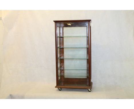 Slim unmarked mahogany and glass counter top display cabinet with five glass shelves, glass door with catch to back on later 