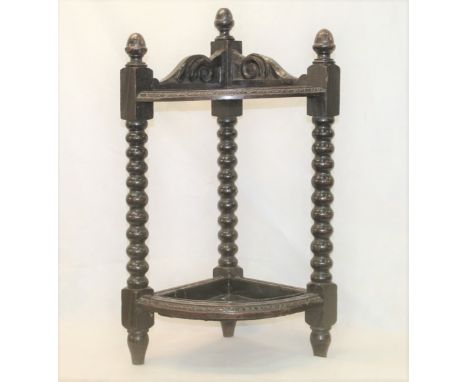 Late 19th century oak short corner stick stand, carved detail to frame, ring twist supports under acorn finials, tin drip tra