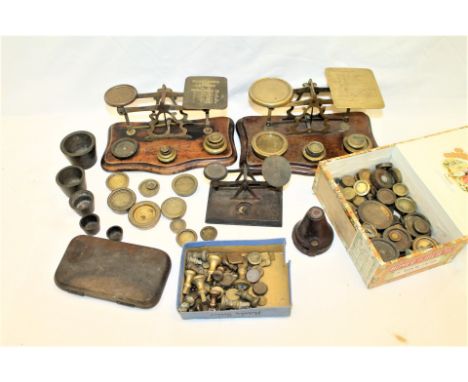 Three brass and wood postal scales and a good quantity of various weights including flat, nested cup etc. 12cm, 23cm and 25cm