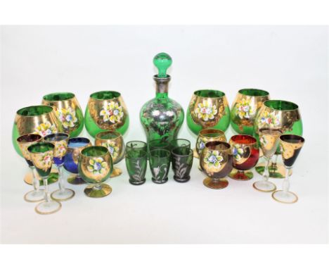 Seventeen Bohemian glasses including six brandy, five sherry and six liqueur, all decorated with enamelled flowers on richly 