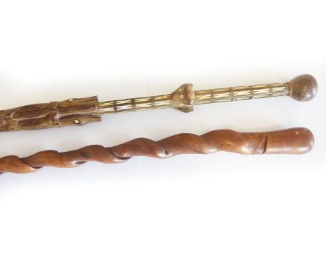 Two walking sticks, one African tribal stick of totem form with carved crocodiles, lions heads, birds, snakes etc. inlaid wit