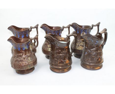 Six copper lustre jugs, the three largest and one smaller  with hunting scenes embellished with blue borders, two others with