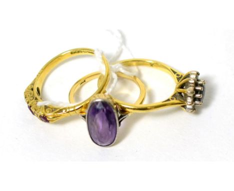 An 18 carat gold ruby and diamond ring, an 18 carat gold sapphire cluster ring and an amethyst ring, stamped '18ct' (3)Ruby a